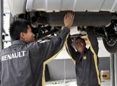 Deux mécaniciens Renault inspectent l'échappement d'une voiture sur un élévateur à Brou en Eure-et-Loir 28