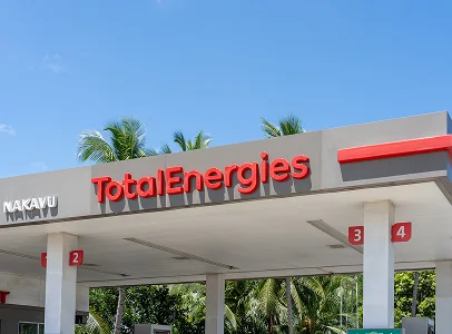 Station-service TotalEnergies sous un ciel bleu avec des palmiers à Brou en Eure-et-Loir 28